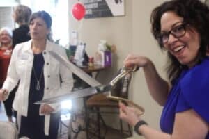 KCA Services Team Member Holding Ribbon Cutting Scissors