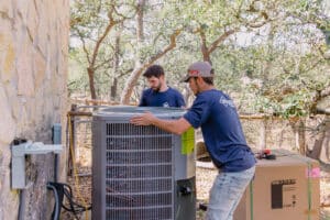 KCA Services Techs Moving HVAC Unit toward House